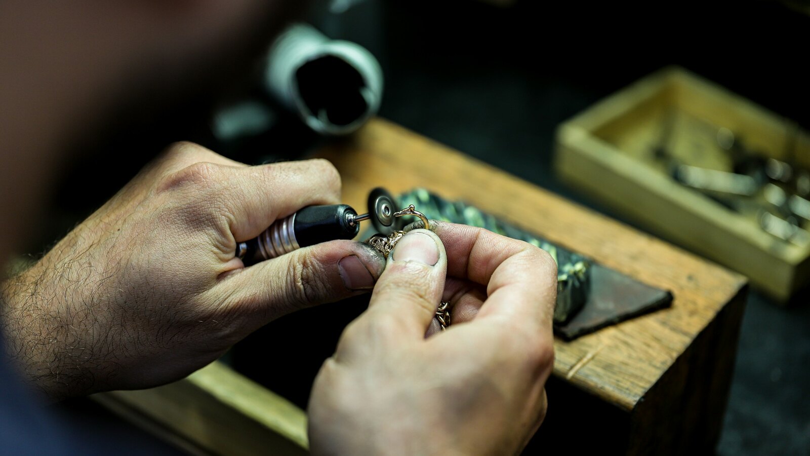 Goldsmith setting a stone into a gold ring at the bench