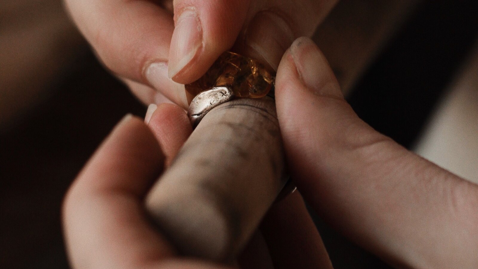 Goldsmith polishing a gold ring by hand