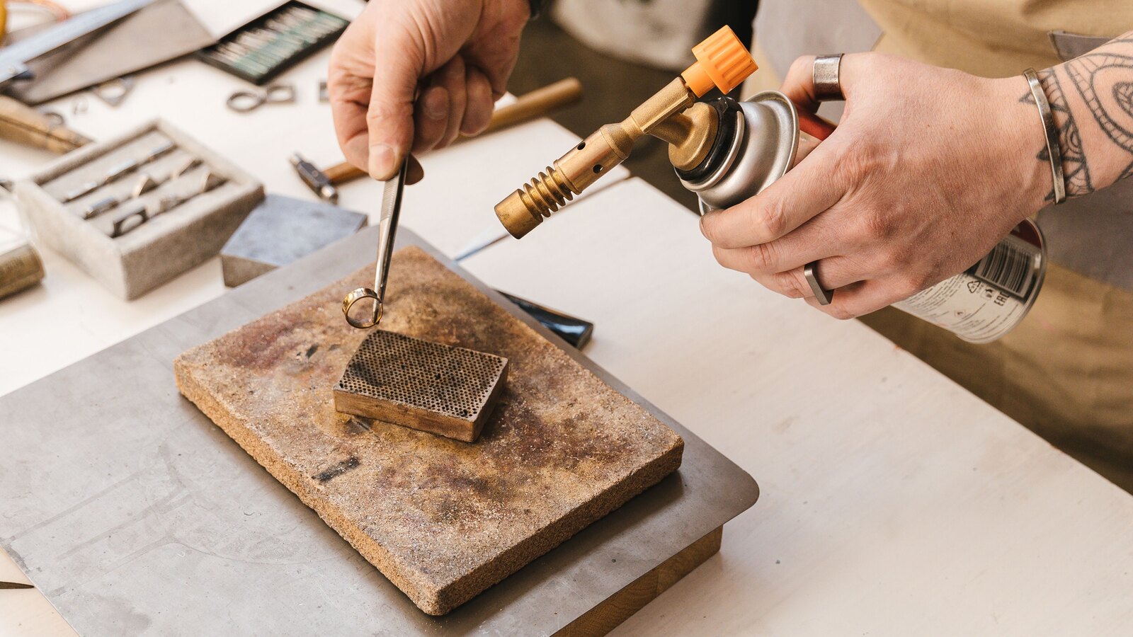 The goldsmith working a piece at the bench